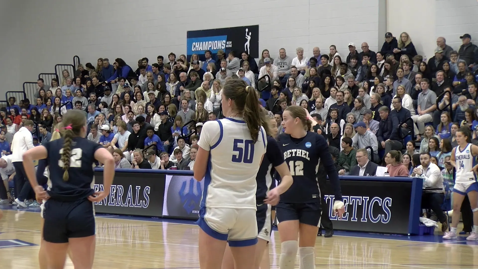 Washington and Lee's Mary Schleusner stands on court against Bethel in front of a packed crowd at Holekamp Gym.