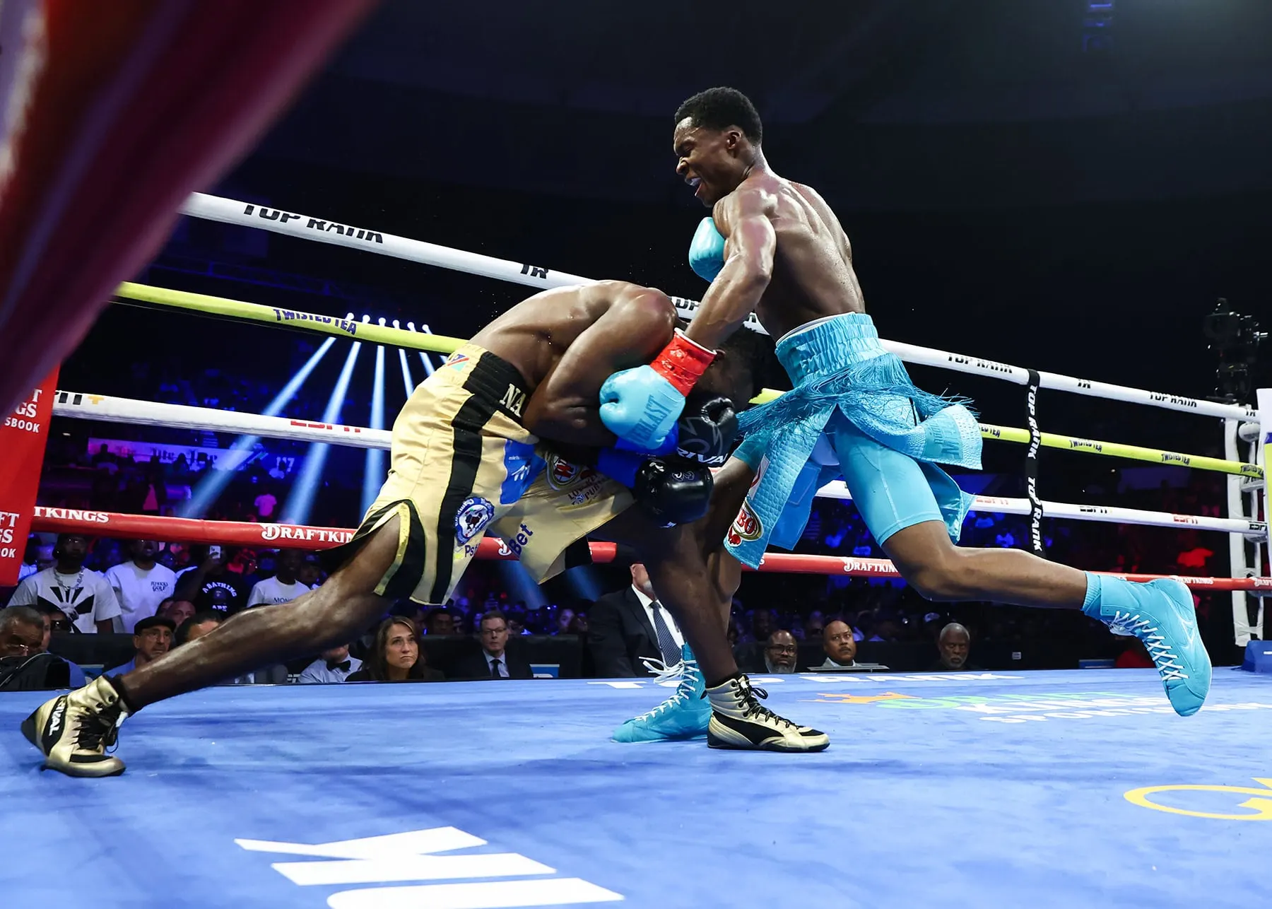 Abdullah Mason and Jeremia Nakathila exchange punches in the ring under bright arena lights.